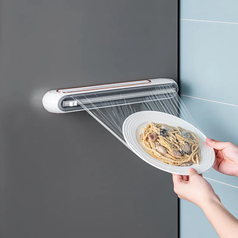 White and blue magnetic cling film cutter hanging on a fridge with a film roll