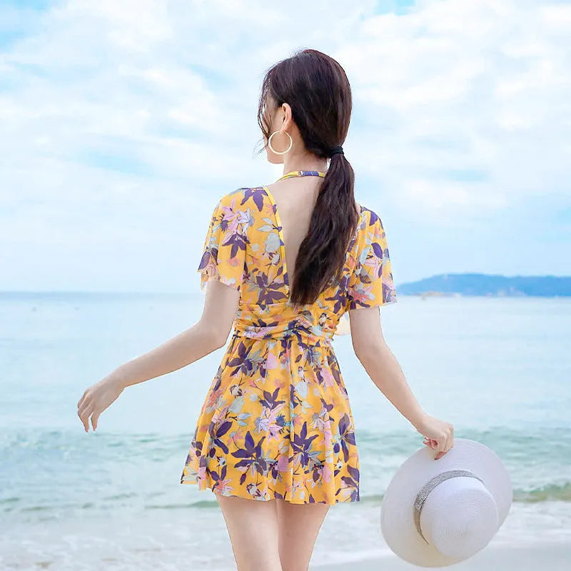 Yellow floral print women's one-piece swimsuit on hanger showing front design