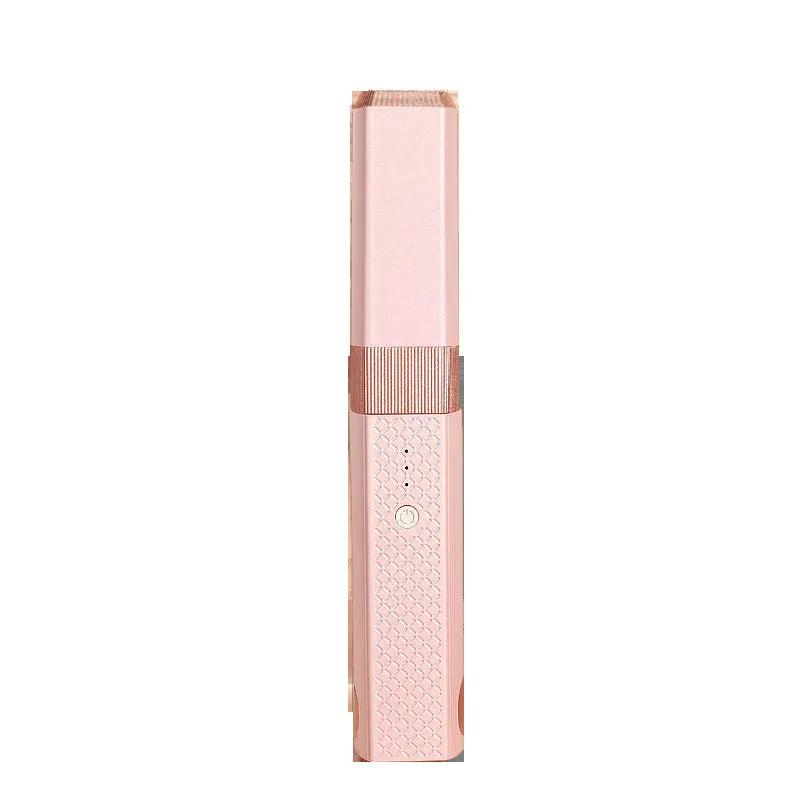 Pink and green mini cordless USB hair straightener with ceramic plates open on a white background.