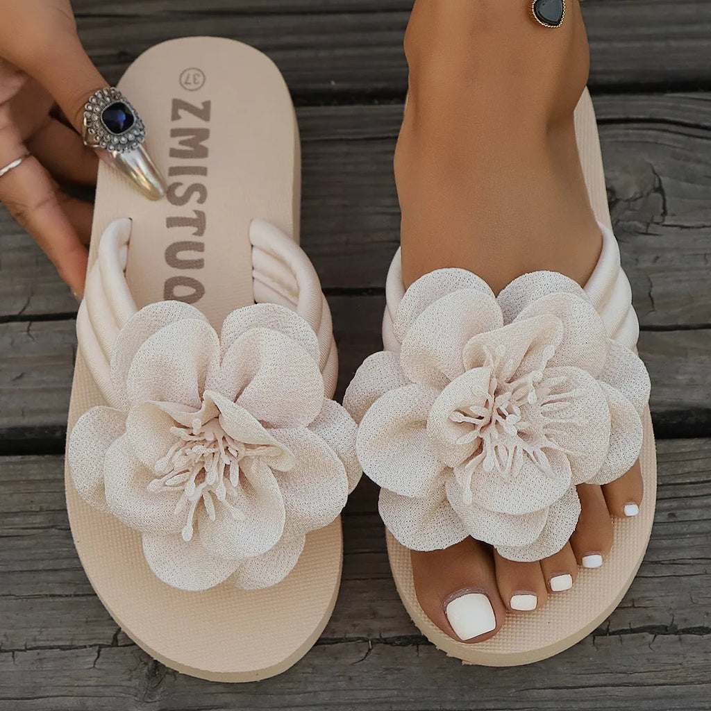 Women's solid colour PU flower flip-flops on a flat surface, showing the strap with decorative flower detail