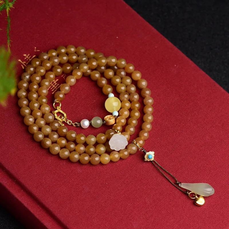 Close-up of a green jade bead bracelet with leaf sequins and a beeswax sheen.