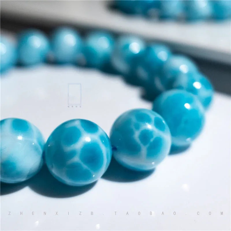 Blue Bodhi bracelet with natural sea-pattern crystal stones and pearl details in Maillard style.