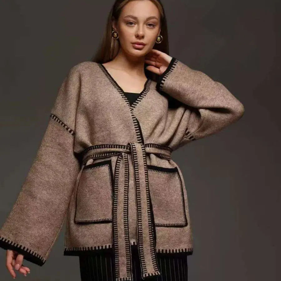 Loose black lace-up knitted cardigan sweater coat with long sleeves.