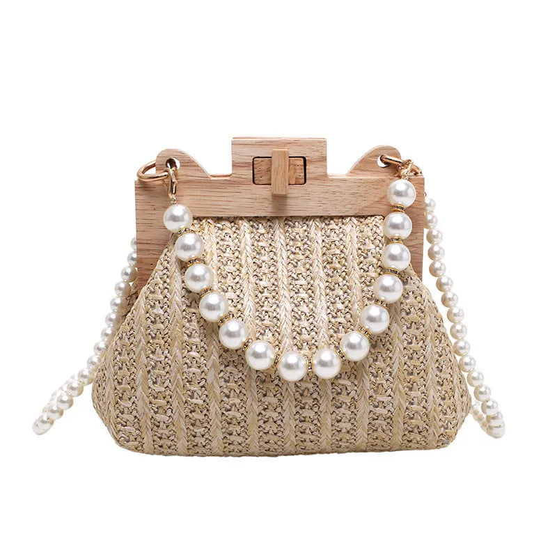 Women's straw woven shoulder bag with pearl chain strap showing interior organisation pockets