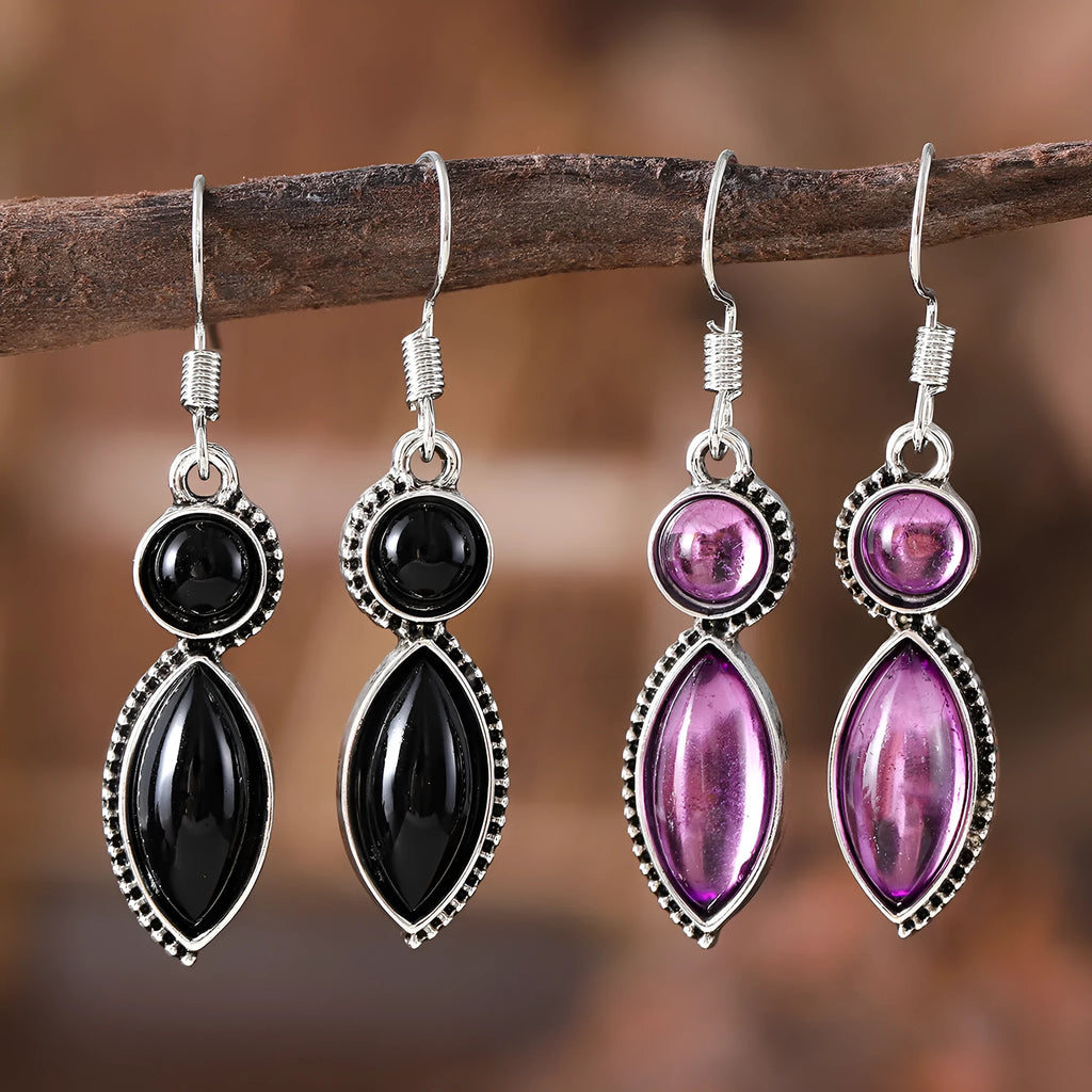 A pair of vintage geometric bohemian pendant earrings in black and purple with round design elements.
