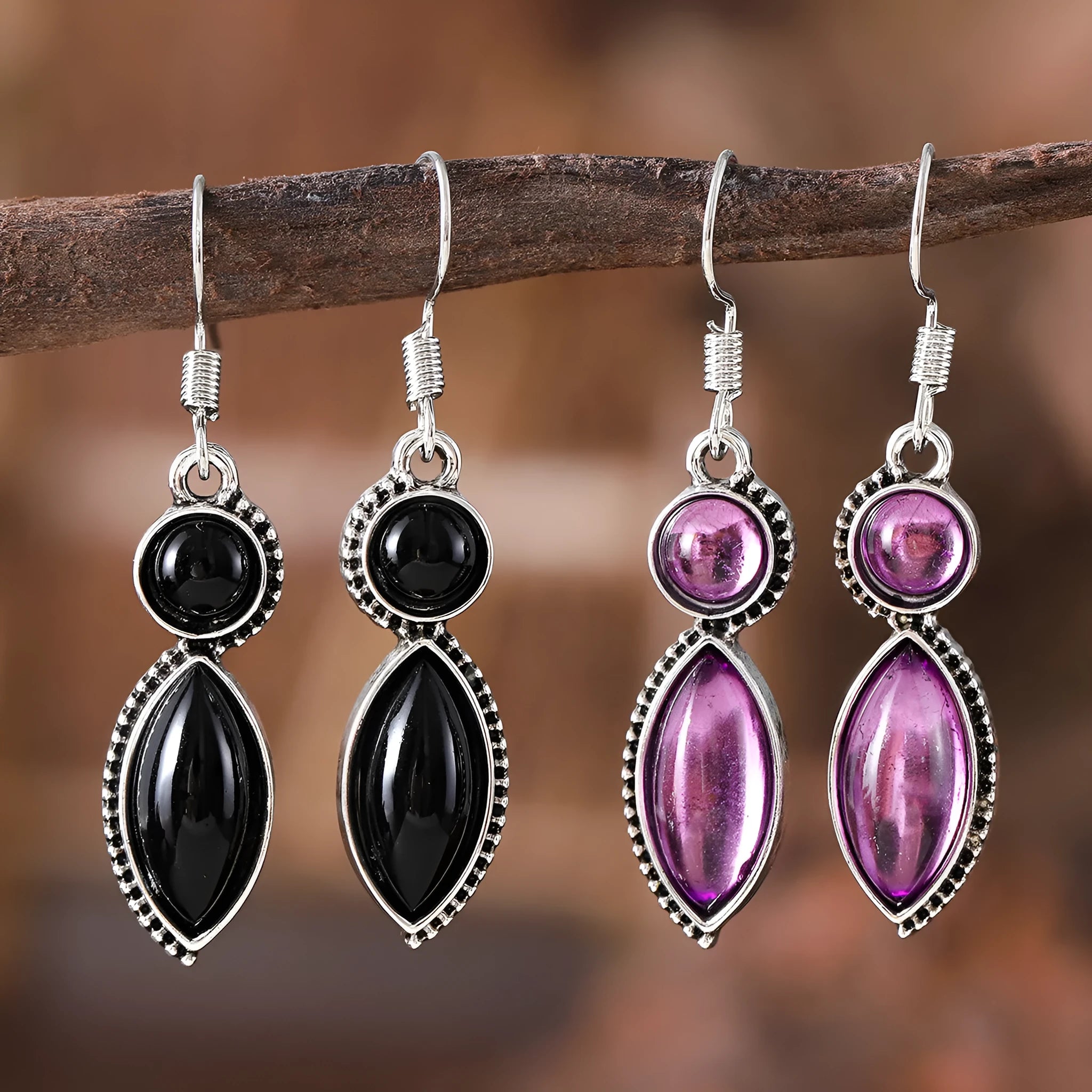 A pair of vintage geometric bohemian pendant earrings in black and purple with round design elements.