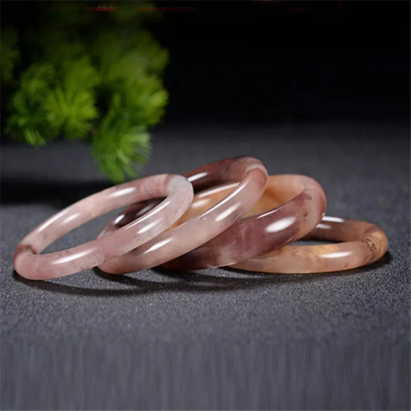 Violet jade bracelet with polished beads shown in flat bar and round bar styles on a wrist.