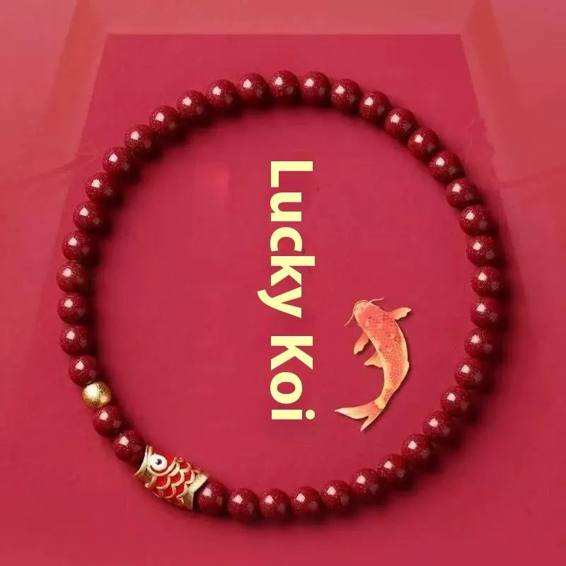 Natural cinnabar koi bracelet with golden ball in national style on a wrist.