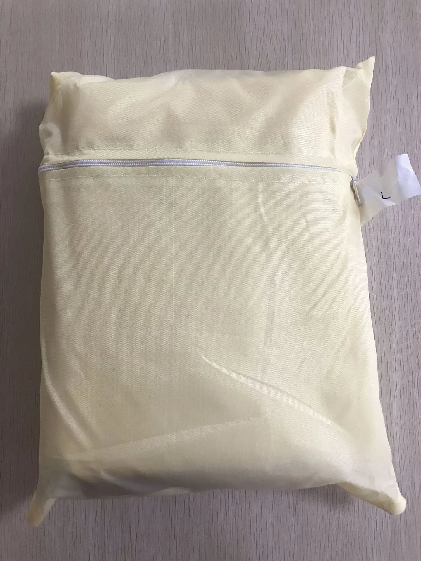 Beige polyester outdoor barbecue dust cover shown folded, with size options listed.