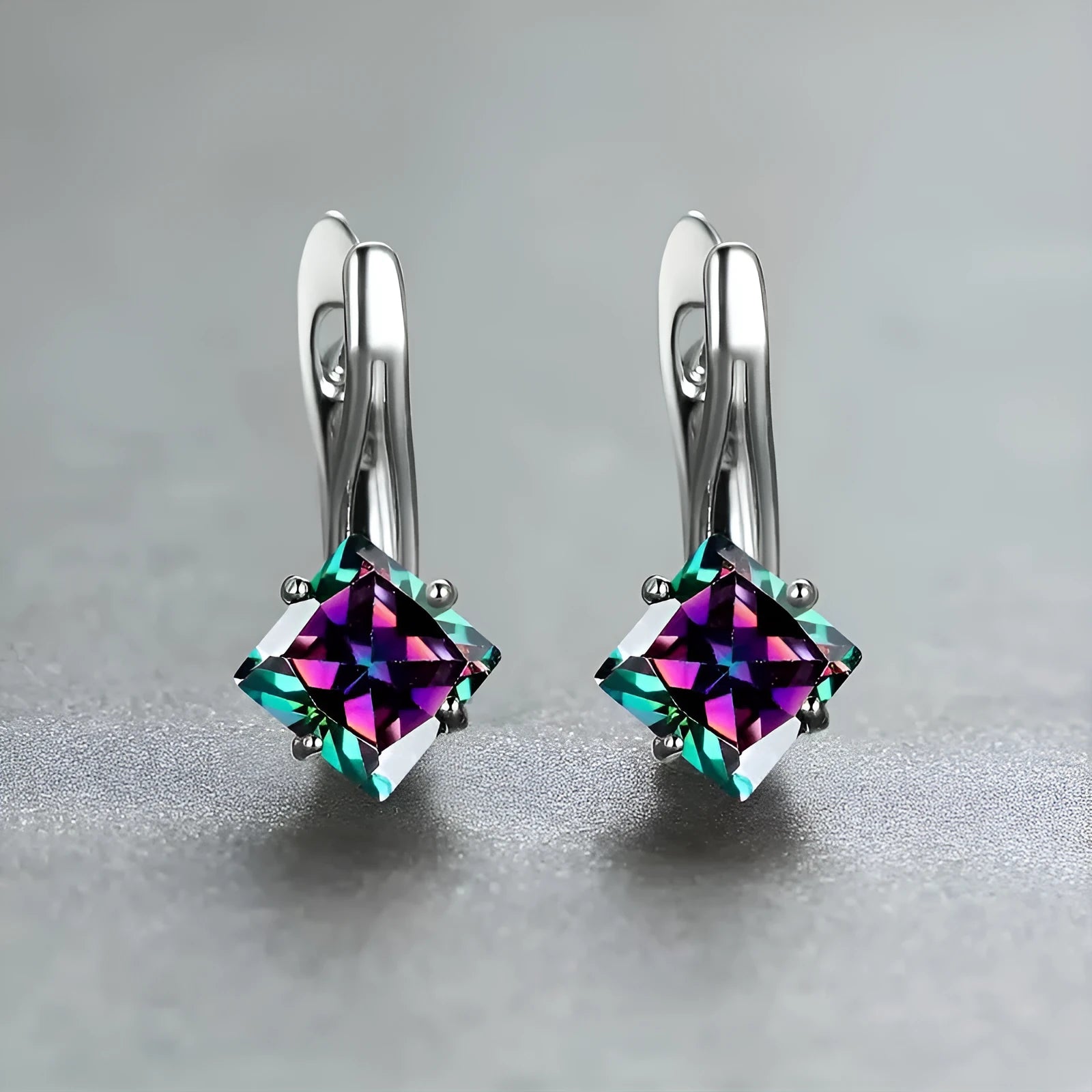 A pair of copper diamond-shaped earrings with inlaid zircon stones, shown in blue, green, and colour variants.