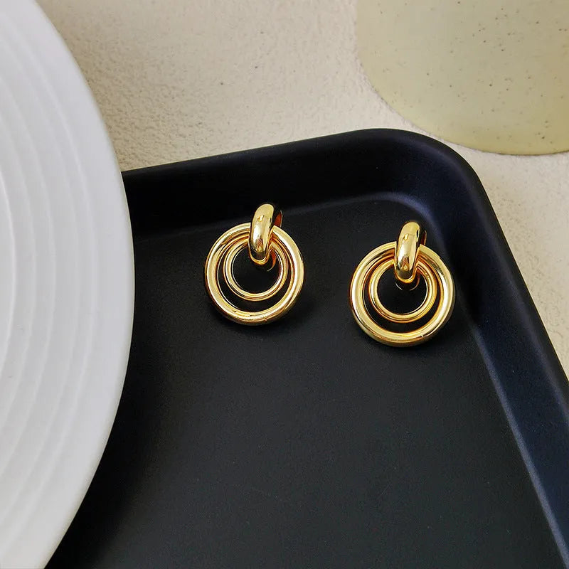 A pair of women's geometric round ring earrings with an irregular shape in a gold electroplated finish.