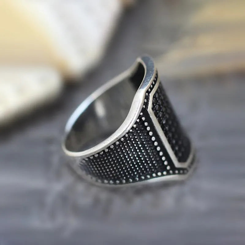 Black alloy ring with copper inlaid zircon detailing showing metallic finish