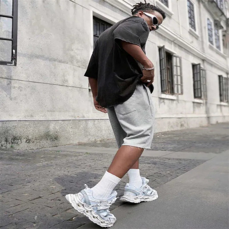 Men's straight leg polyester trousers in black, shown in a streetwear style pose.