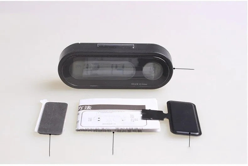 Black electronic car clock and thermometer with luminous digital display on an adjustable dashboard mount.