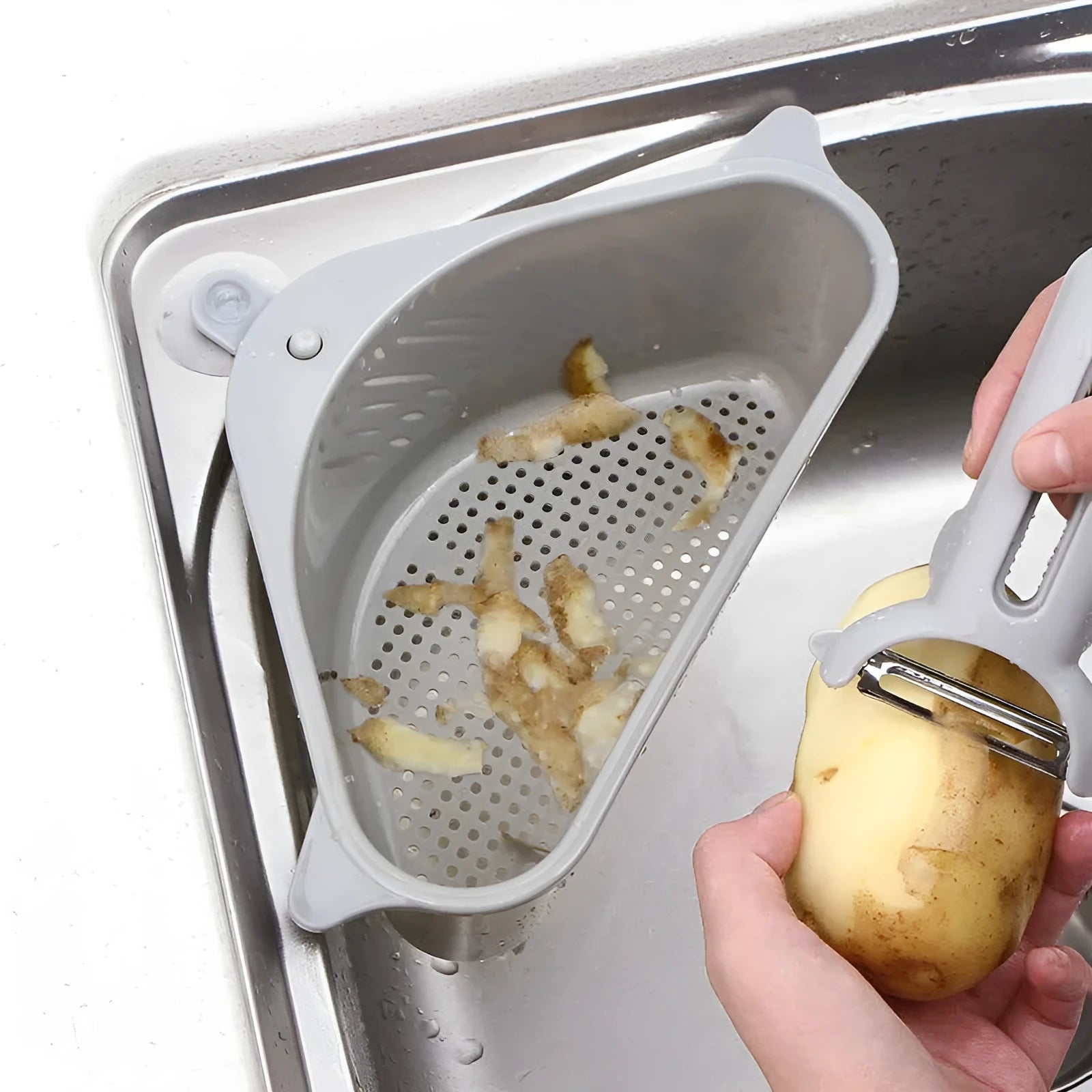 Beige plastic triangle sponge drain rack hanging from a kitchen faucet.