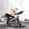 Black upright spinning bike with console and infinite resistance knob on a home gym floor