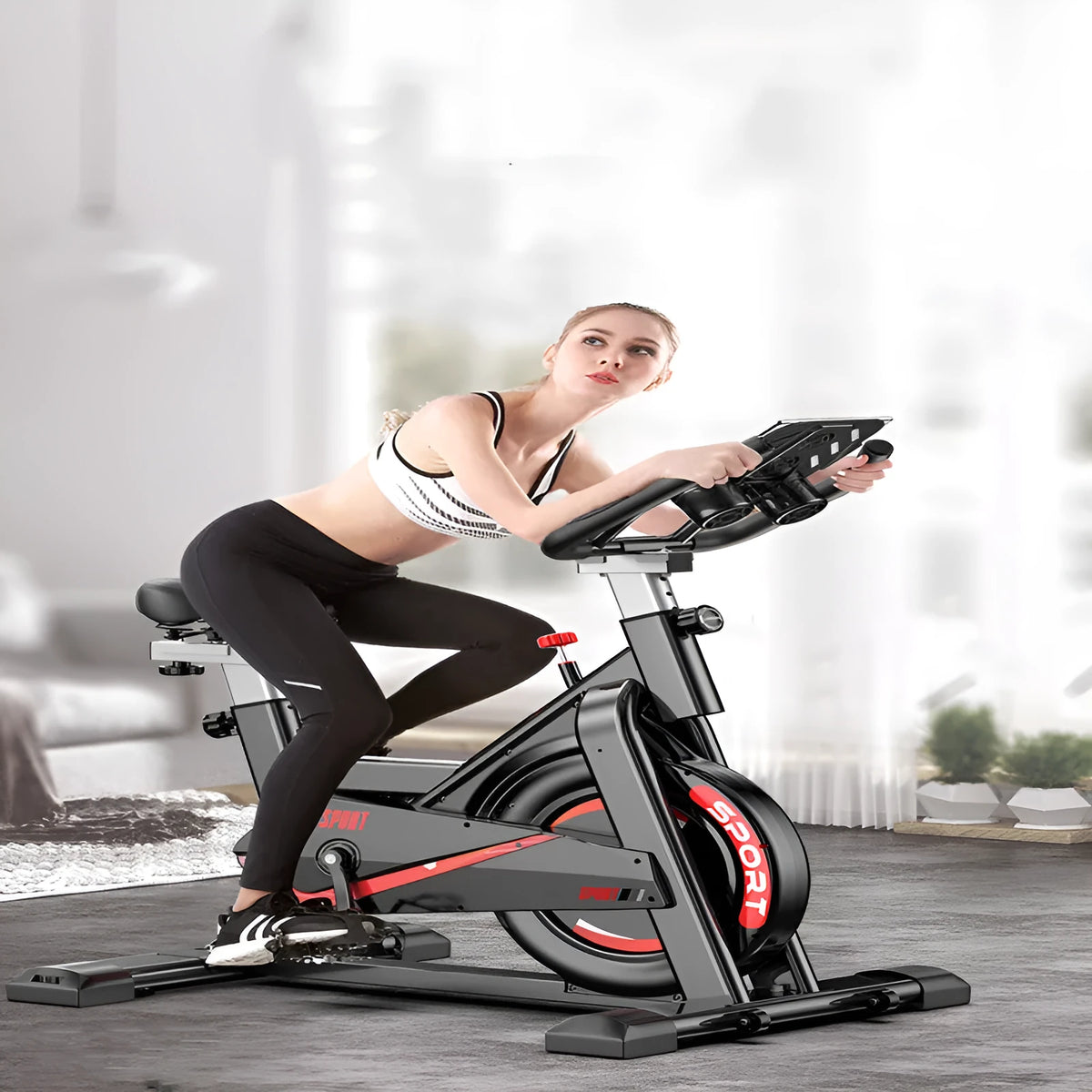 Black upright spinning bike with console and infinite resistance knob on a home gym floor