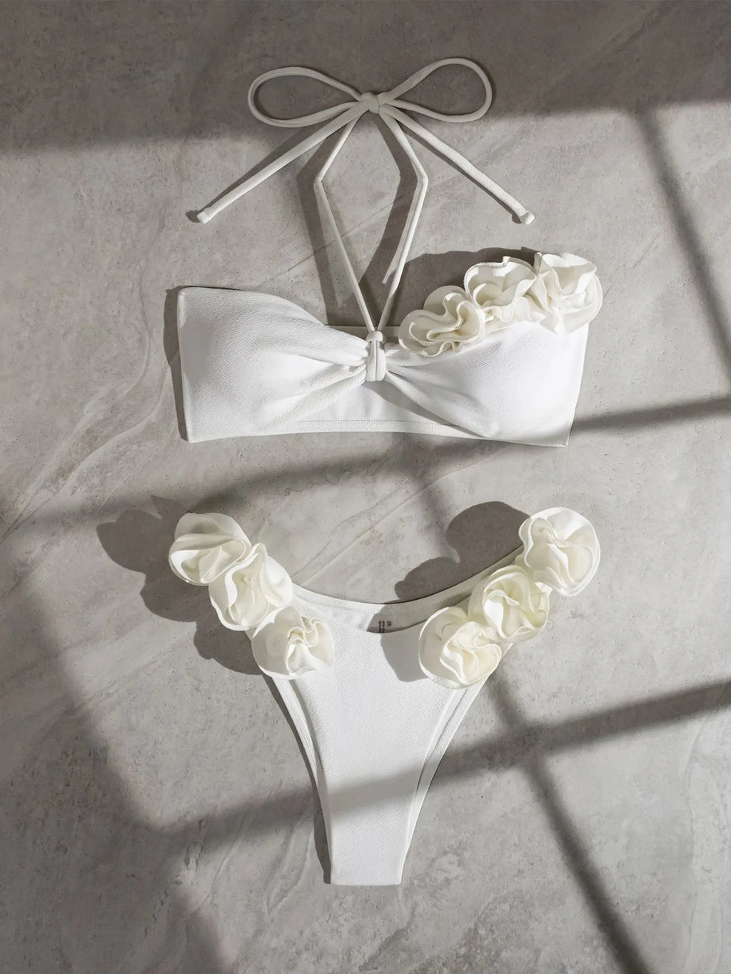 White halter swimsuit with three-dimensional floral lace-up front and split sides