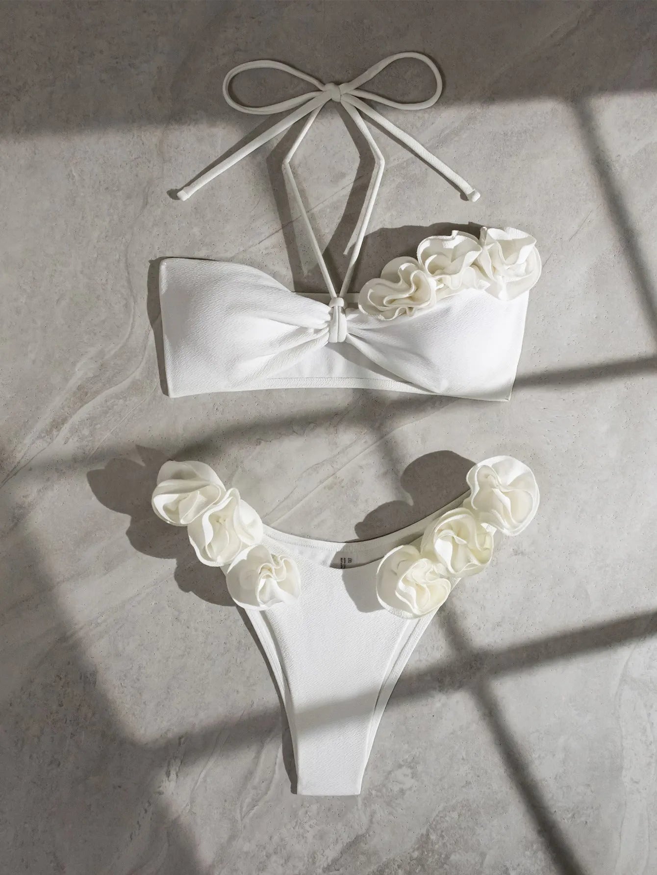 White halter swimsuit with three-dimensional floral lace-up front and split sides