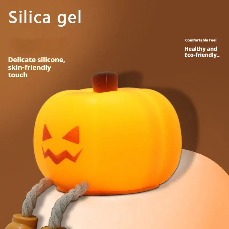 Soft orange pumpkin-shaped silicone night light with a warm glow, showing its compact size on a table.