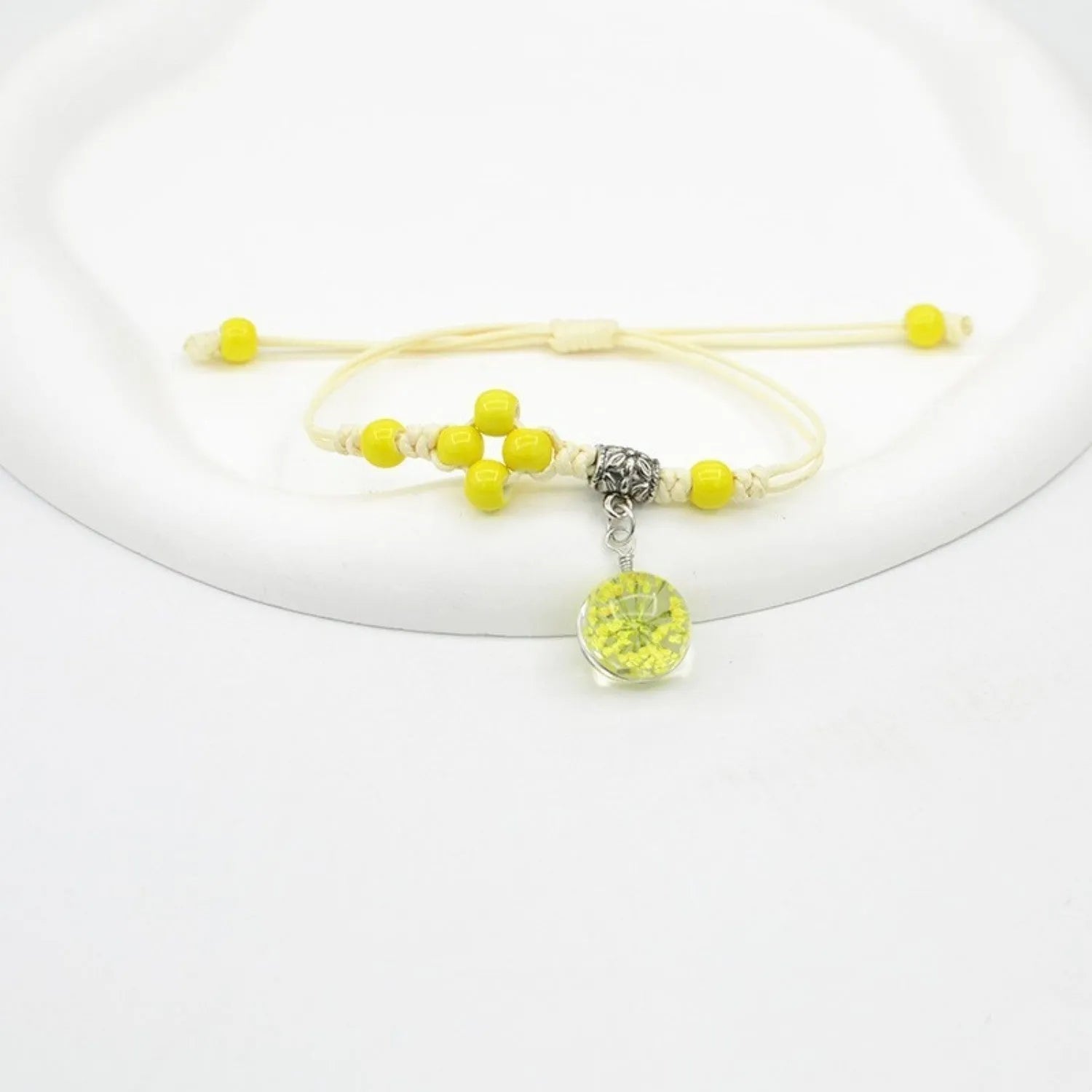 Close-up of a hand-woven glass bracelet with large 1.4cm beads containing real dried flowers in various colours.