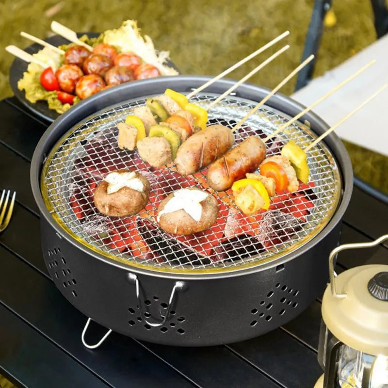 Portable stainless steel campfire grill with detachable parts and storage bag on grass