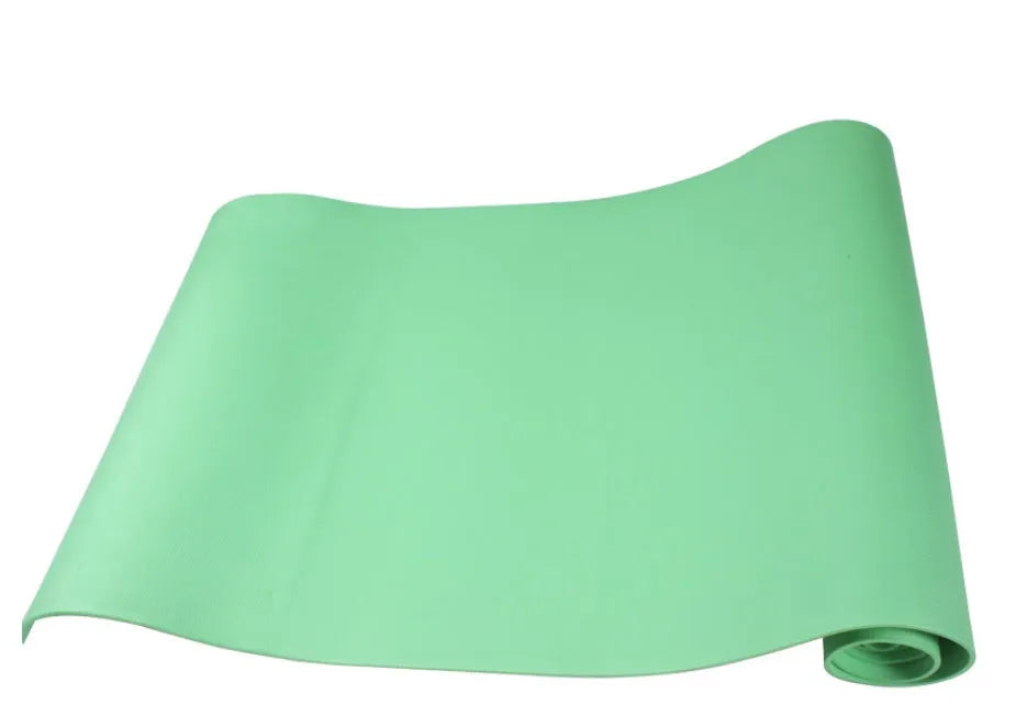 Red EVA fitness yoga mat with rolled edge showing thickness, laid flat on a wooden floor.