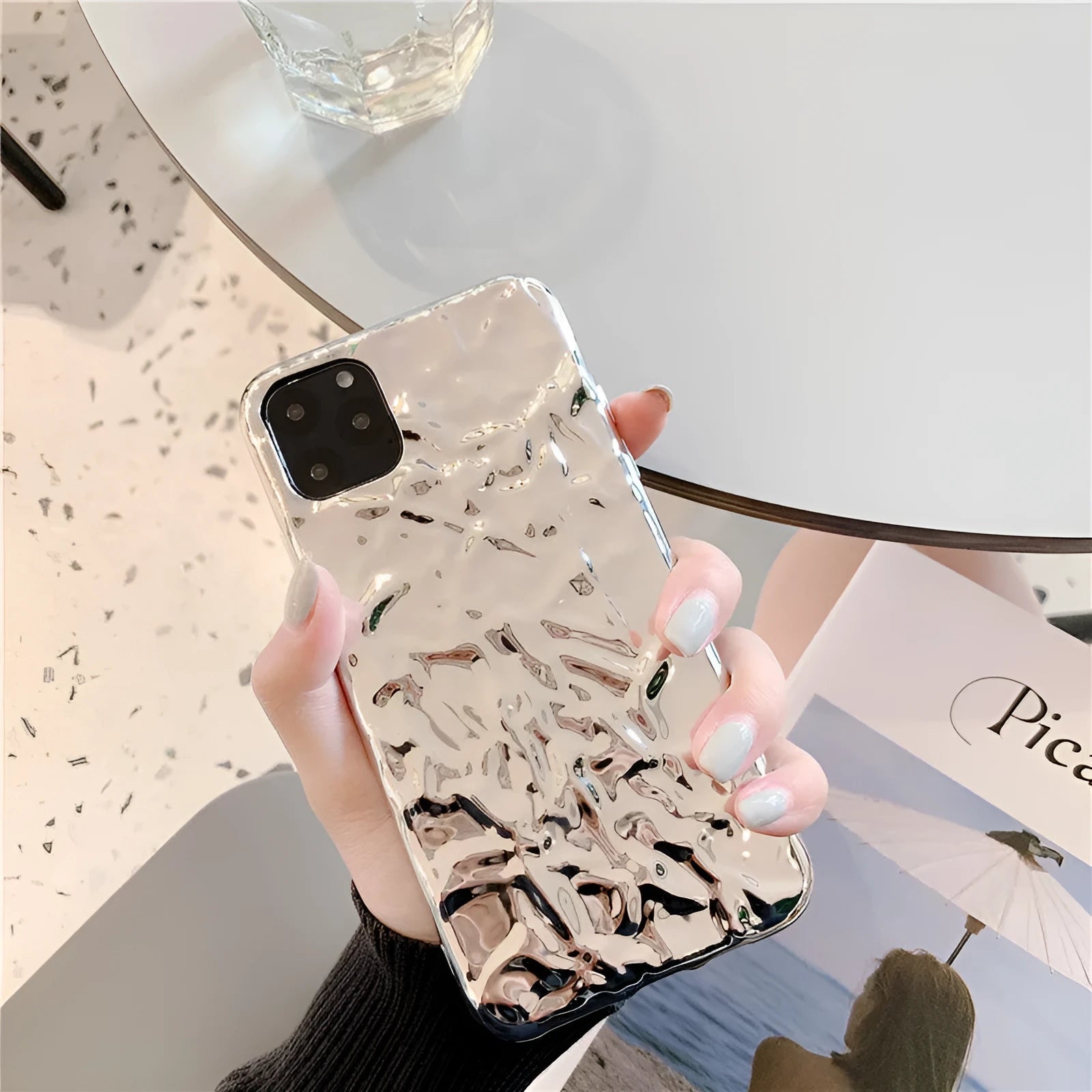 Rose gold and silver folded TPU back cover cases for various iPhone models on a plain surface.