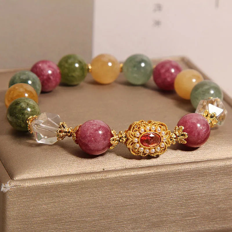 Close-up of a women's bracelet with multicolour tourmaline beads on an alloy band with crystal and rhinestone details.