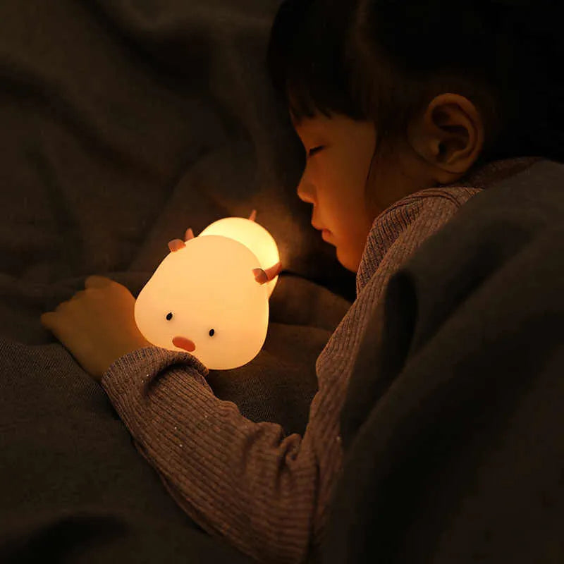 Blue silicone pig-shaped night light with sleeping design and USB charging port