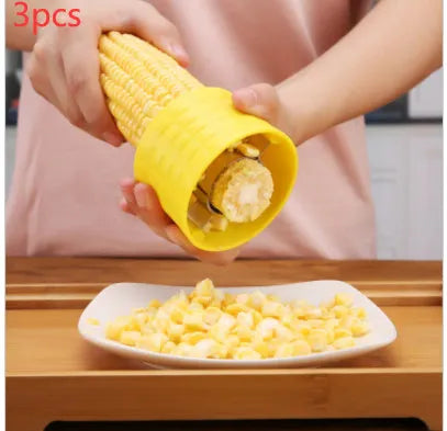 Yellow manual corn grinder thresher kitchen tool with corn-shaped design and stainless steel gear.