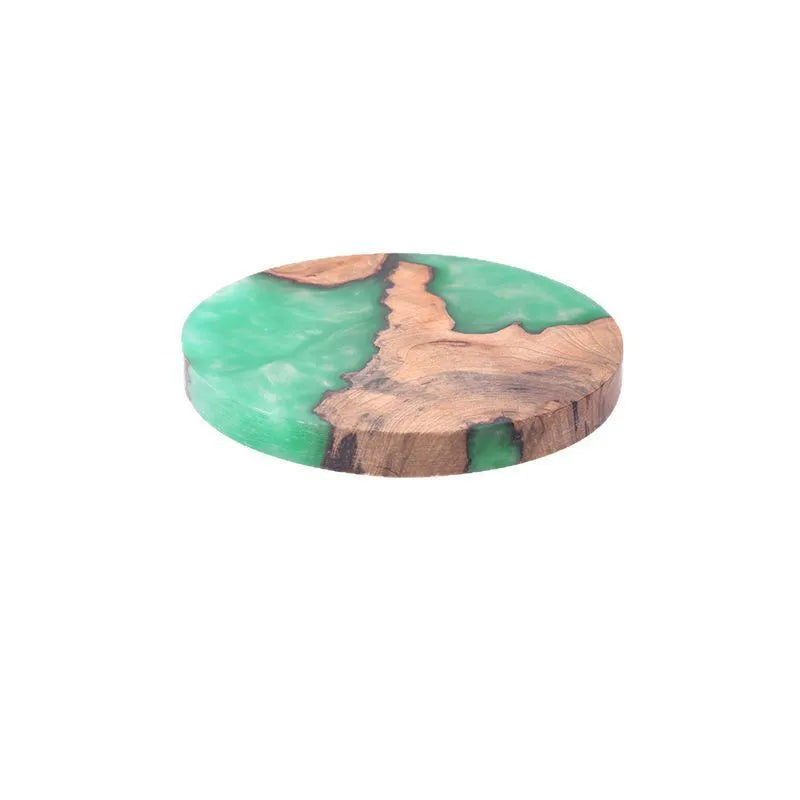 Wooden coaster with heat insulation resin in round tumour green colour on a table.