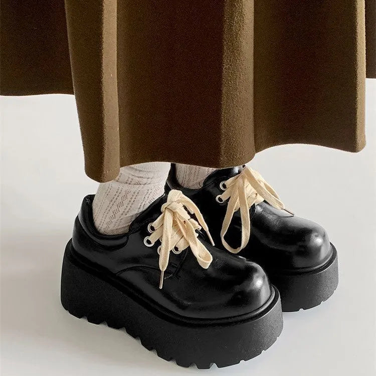 Matte black women's lace-up shoes with a chunky English muffin heel and thick rubber sole.