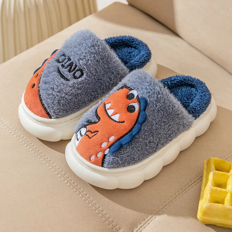 A pair of plush grey dinosaur-themed couple slippers with a thick sole, shown next to coffee and orange colour variants.