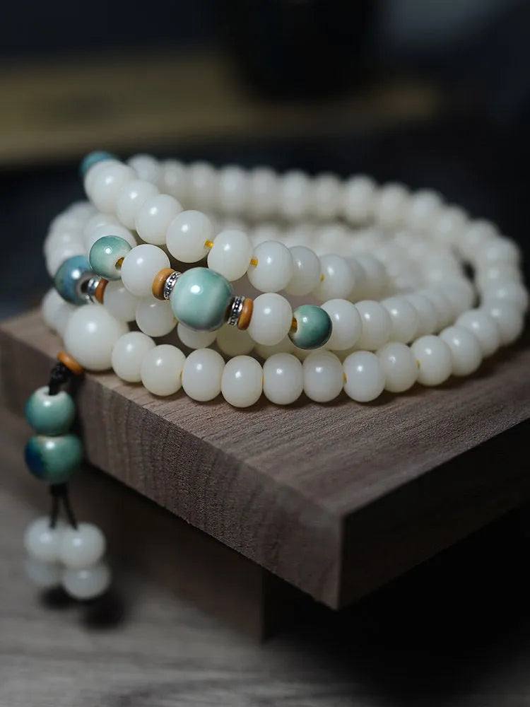White jade bodhi root bracelet with 108 flat round beads in two sizes on wrist