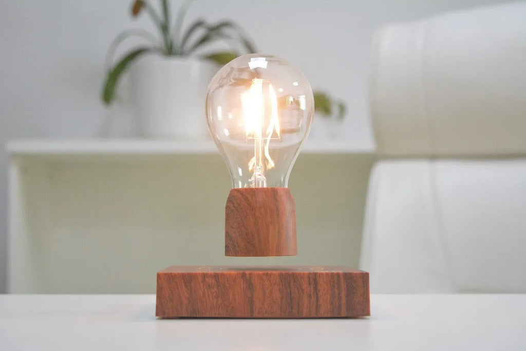 Magnetic levitation light bulb floating above its imitation wood base.