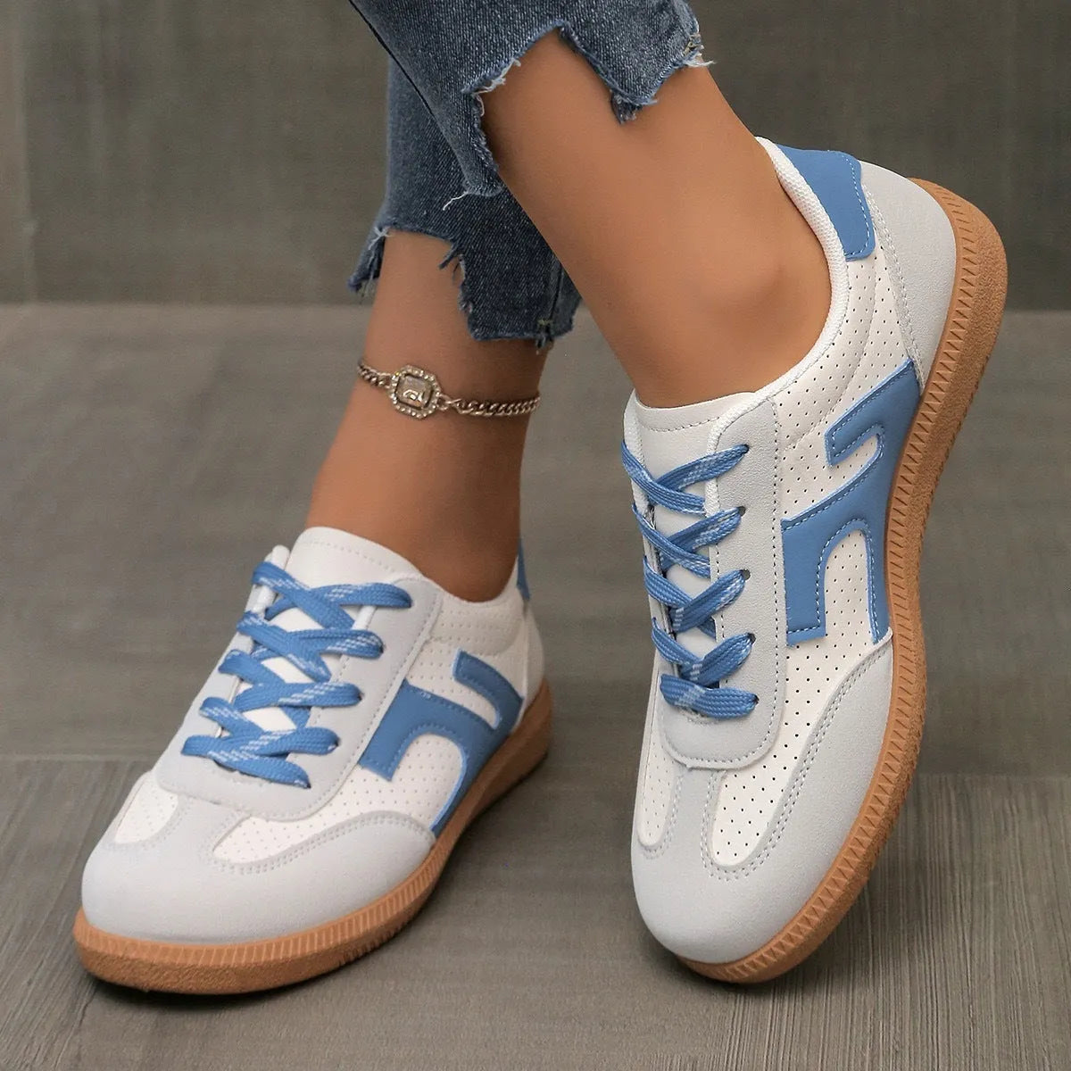 A pair of retro-style low-top lace-up sneakers in a selected colour on a plain background.