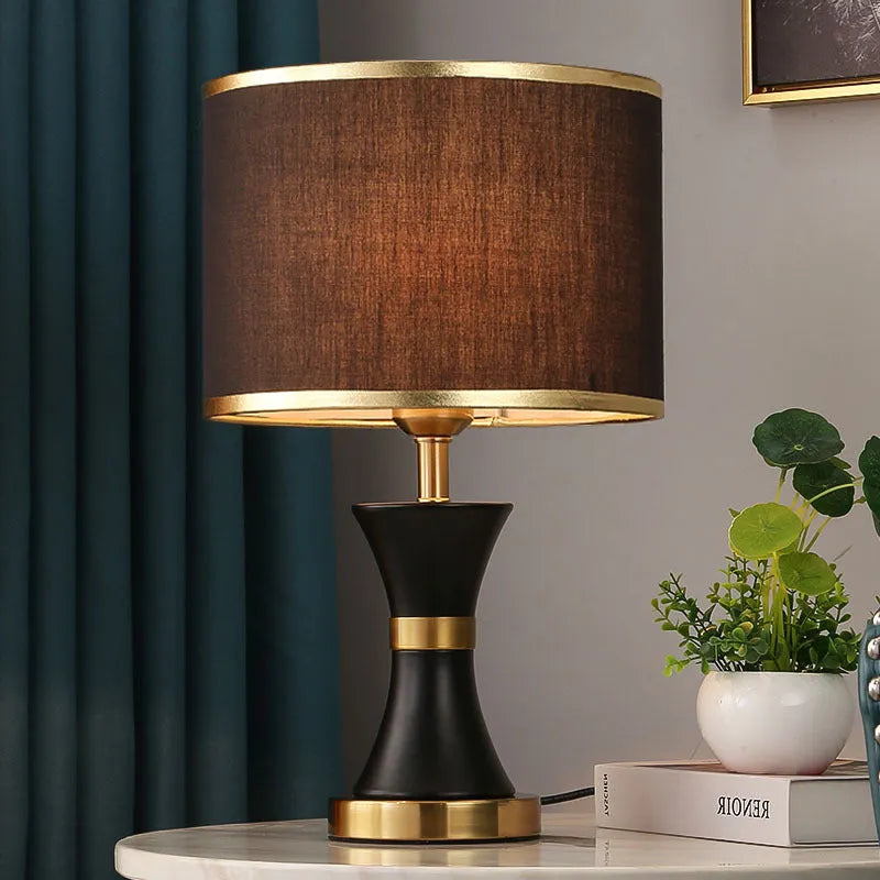 Black, gold, or white bedside table lamp with a fabric shade and iron base