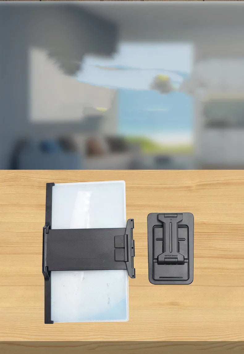 Black foldable mobile phone screen amplifier with detachable holder on a desk
