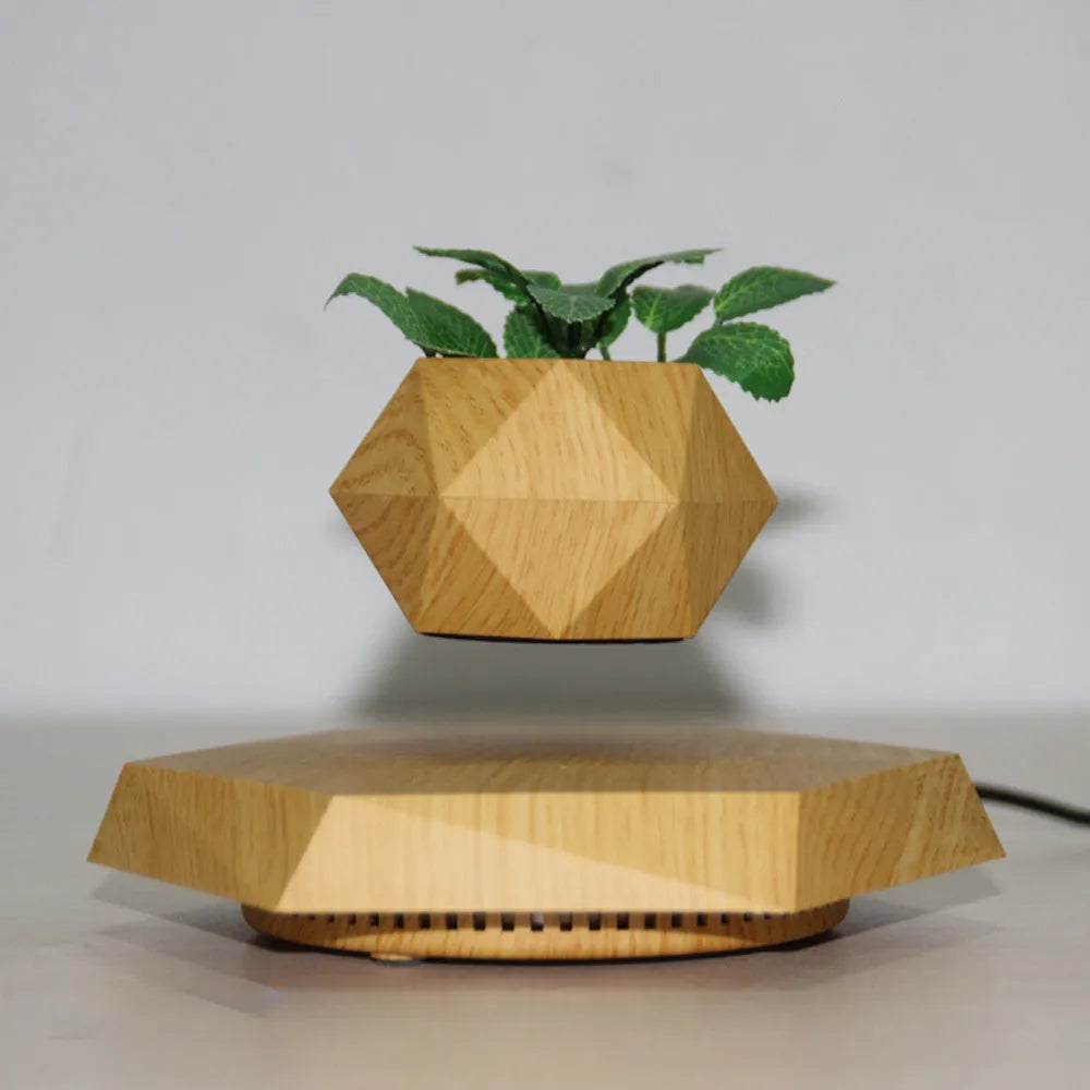 Hexagonal wood grain magnetic levitating flower pot floating above a circular black base on a desk.