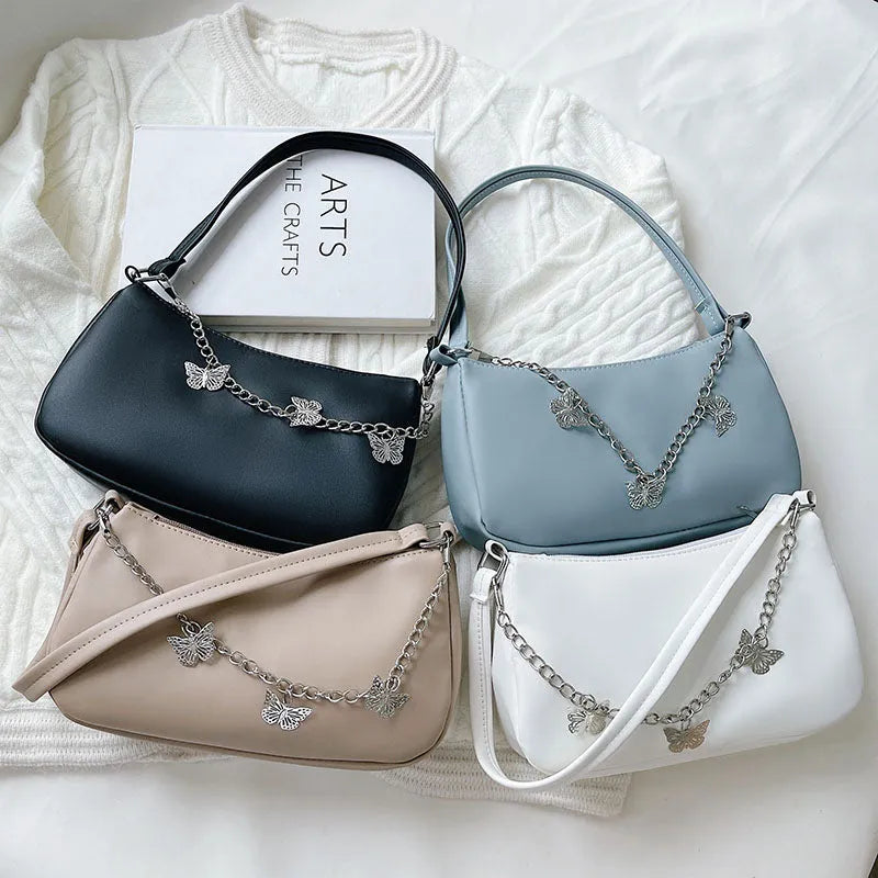 Women's black retro-style crossbody bag with chain strap and structured square shape.