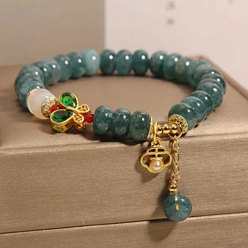 Blue water jade abacus bead and white agate bracelet with alloy and rhinestone details for women.
