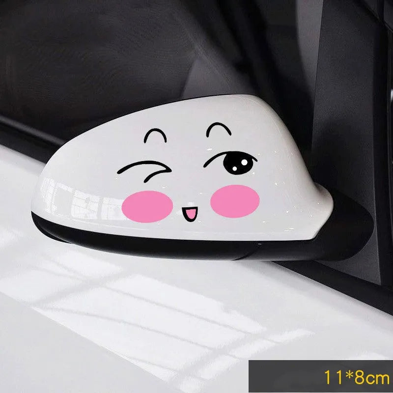 Pair of reflective cartoon eye car stickers on a vehicle rearview mirror.