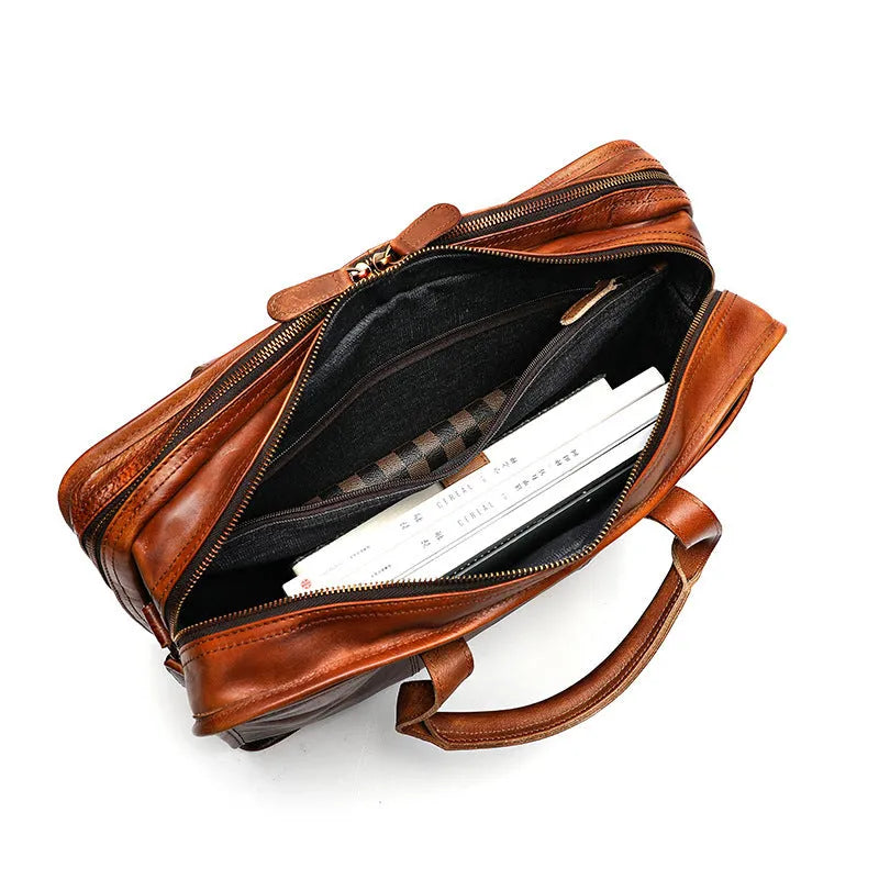 Brown vintage leather men's briefcase showing internal organiser pockets and a shoulder strap.