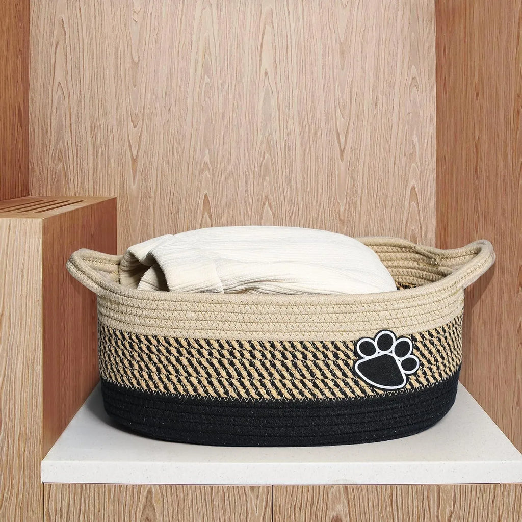 Light beige handmade woven cotton rope storage basket with wooden handle.