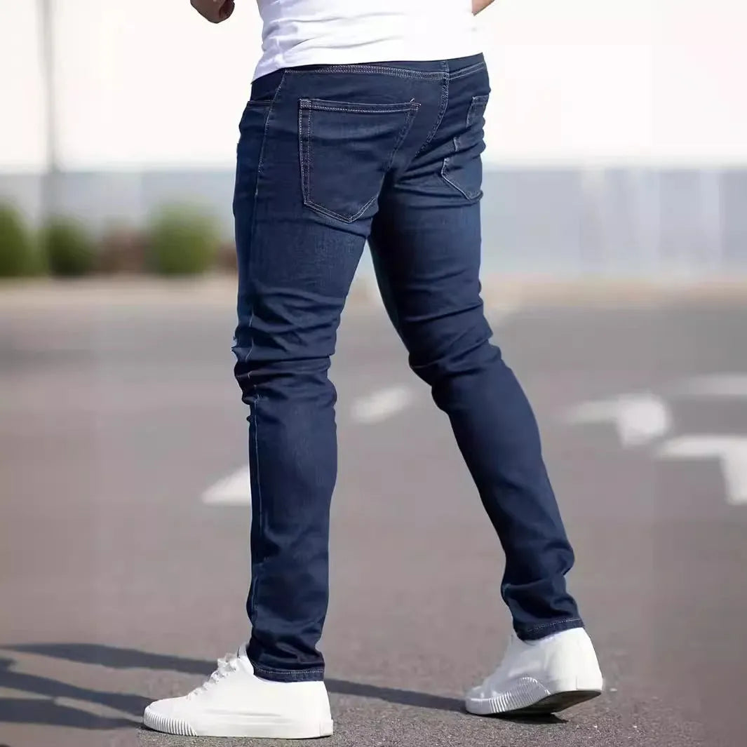 A man wearing dark blue slim fit casual jeans with an elastic waistband.