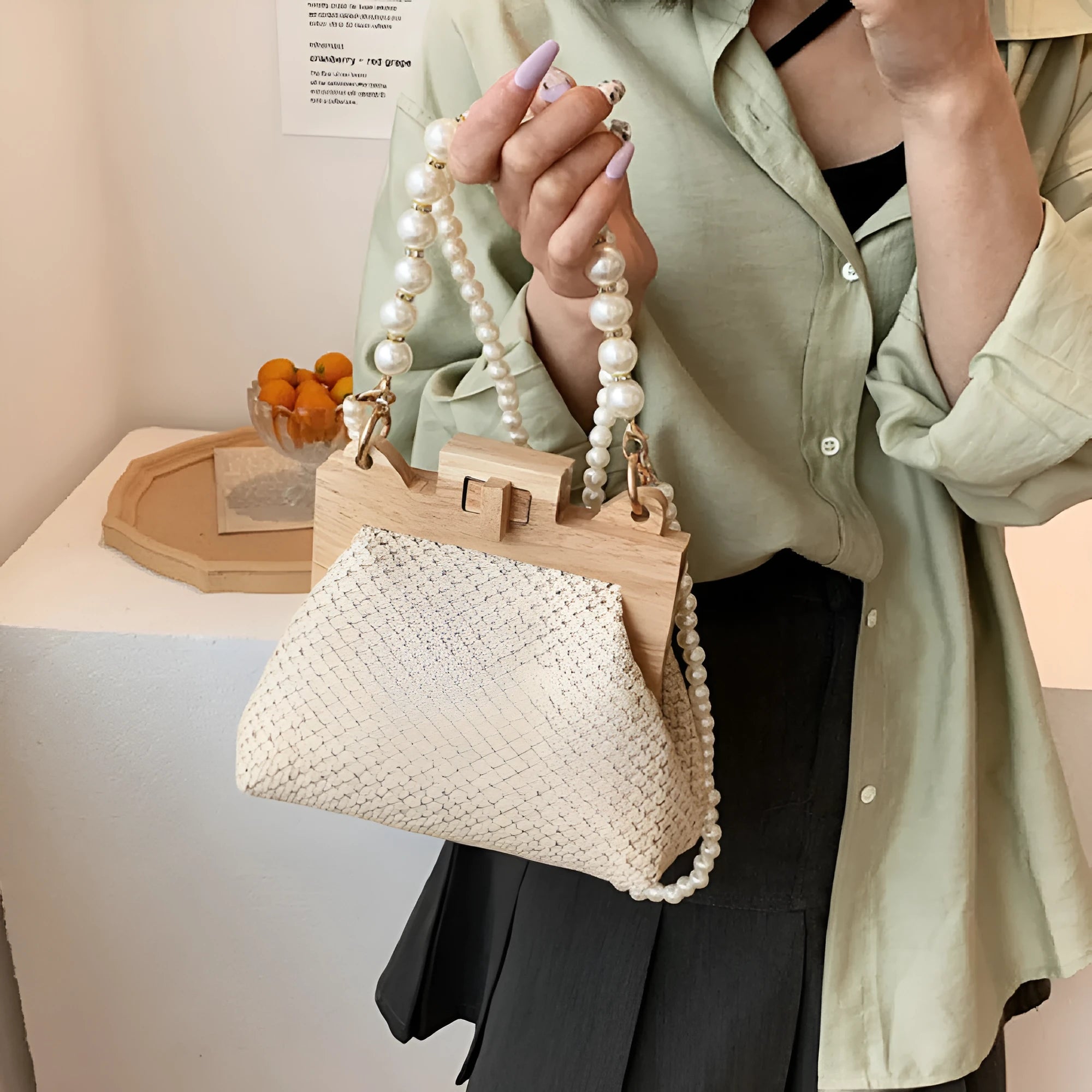 Women's straw woven shoulder bag with pearl chain strap showing interior organisation pockets