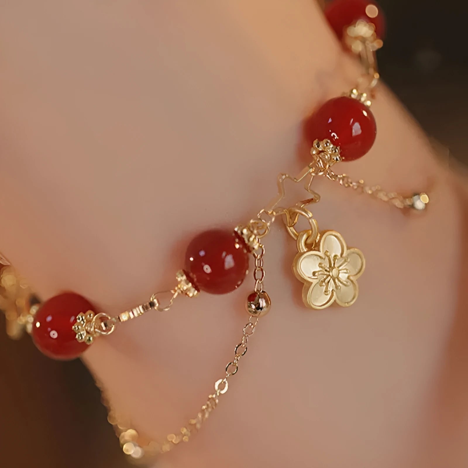 Women's double layer bracelet made from natural red agate with peach blossom decorations.