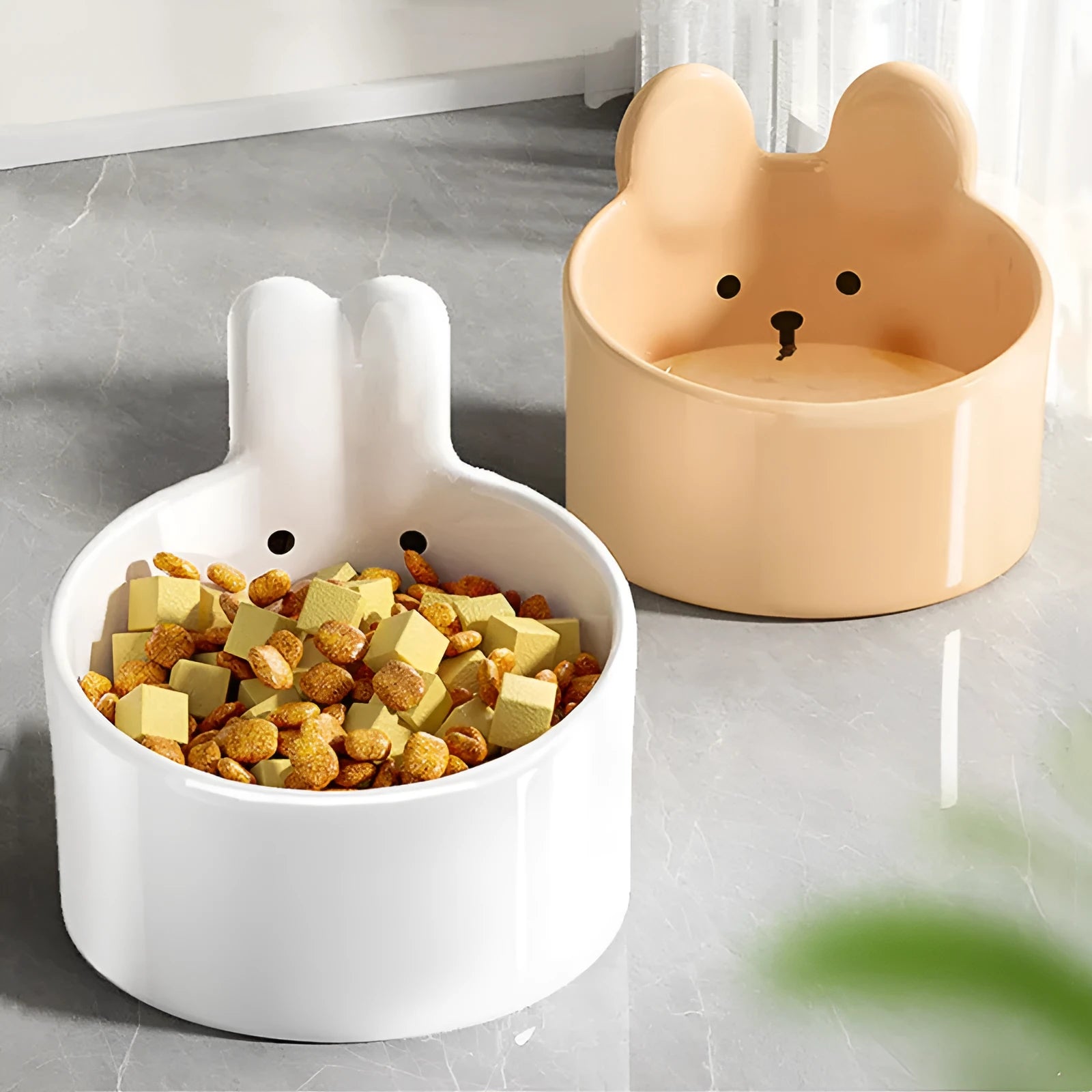White and yellow ceramic pet bowls with raised neck guards in two sizes.