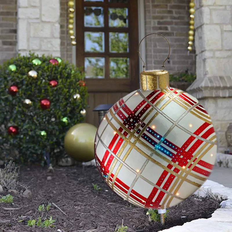Large red and white striped inflatable Christmas ball ornament hanging on an outdoor tree